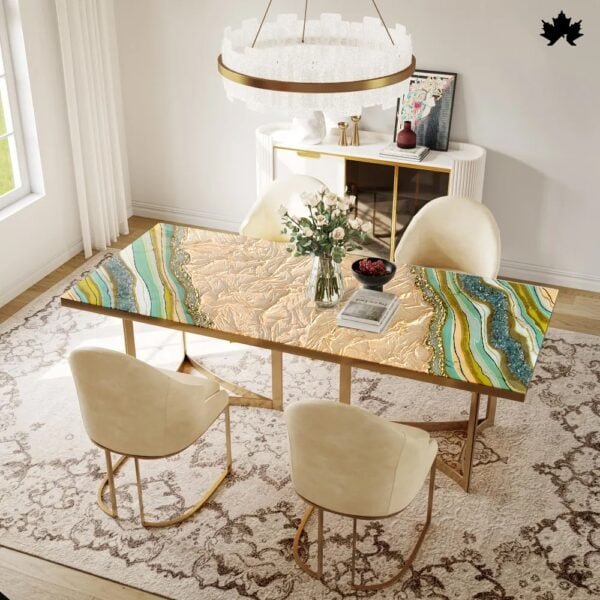 Modern dining table featuring a unique, artistic resin top with swirling patterns in blue, gold, and sandy hues, reminiscent of the beach and ocean waves. Paired with elegant gold-framed chairs and positioned on a classic patterned rug in a bright dining room setting. This table exemplifies contemporary luxury and style, perfect for stylish, modern homes.