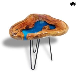 Unique Handcrafted Wooden coffee table featuring a natural wooden top with a vibrant blue resin insert that mimics a flowing river. The organic shape of the tabletop is enhanced by the clear, glossy finish that highlights the wood's rich grain and colors. This artisan table is supported by three slender, black hairpin legs, making it a striking addition to any contemporary living space.