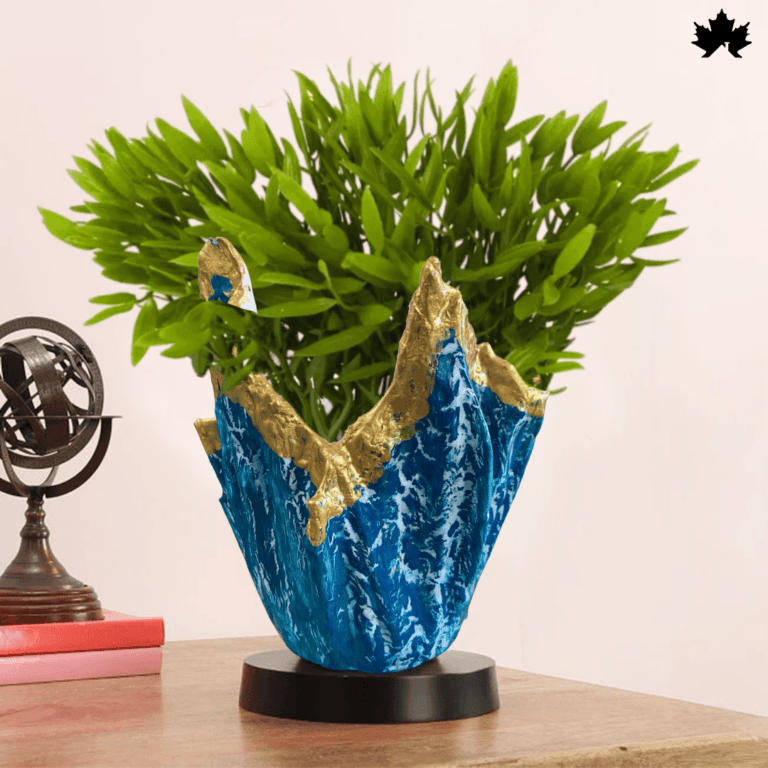 Oceanic Crest – Custom Plant Container a visually striking custom plant container from Fankaarlok, featuring deep blue resin with golden accents that emulate the dynamic waves of the ocean, perfectly complemented by a vibrant green plant.