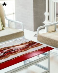 Modern artistic coffee table featuring a distressed silver and red resin top, creating a striking abstract pattern. The table is framed with a bold red border and supported by black metal legs. A small glass jar with a festive arrangement of greenery and white berries adds a touch of holiday spirit, complementing the vibrant and textured surface of the table.