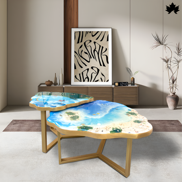 Stunning custom tables by Fankaarlok, featuring a unique two-piece set designed to represent the sky and ocean. The first table showcases a vivid blue sky with cloud details, while the second captures an ocean scene complete with sandy shores and shallow waters. Both tables are set in a modern living room environment, highlighting their artistic design and functional appeal.