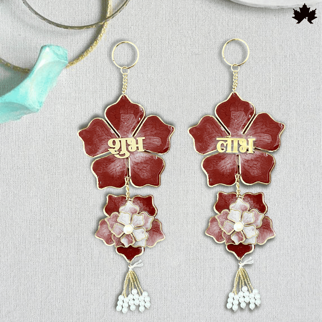 Elegant custom keychains in the shape of a lotus, crafted with deep red resin petals and gold borders, featuring the Hindi words 'शुभ' and 'लाभ' in gold lettering, symbolizing good fortune and profit. Each keychain has a detailed white floral pendant and a cluster of small white beads hanging below, combining traditional Indian motifs with a contemporary design, ideal for auspicious gifts or personal use.