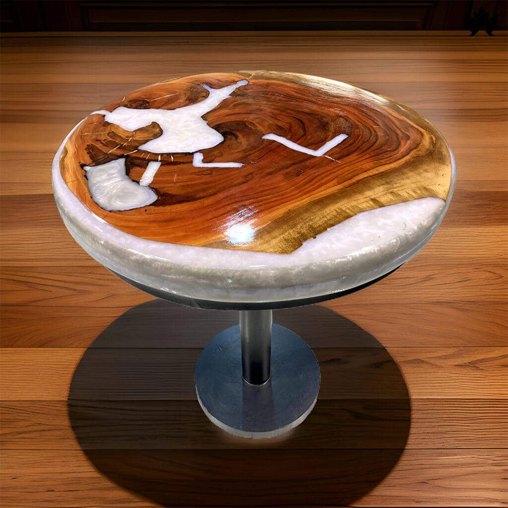 A round artisan handmade wood resin featuring a unique blend of natural wood and white resin patterns, with abstract designs that evoke a snowy landscape across a warm wooden surface, all supported by a sleek, metallic pedestal base.